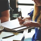 Stock image of woman writing in notepad